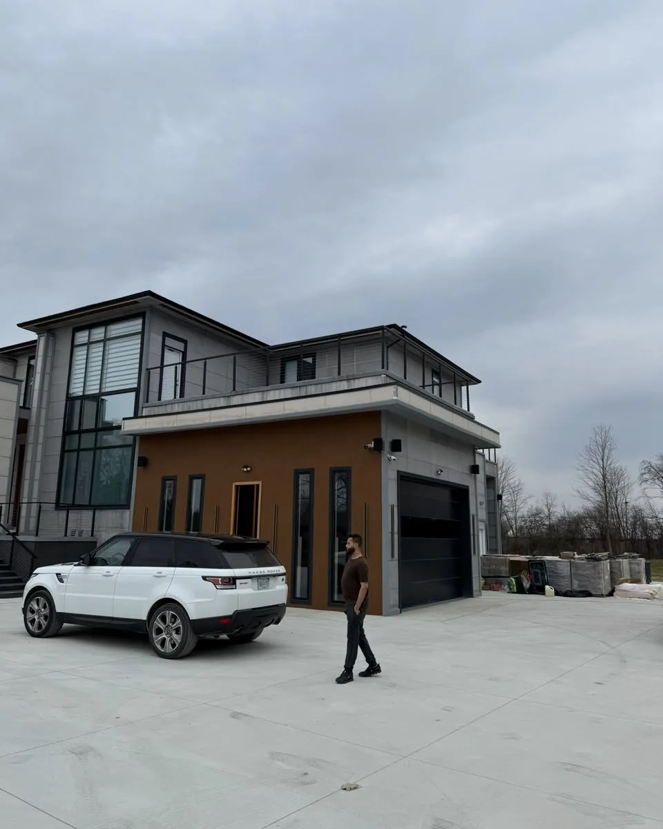 Modern two-story building with gray exterior panels, tall windows and a wood-tone entrance